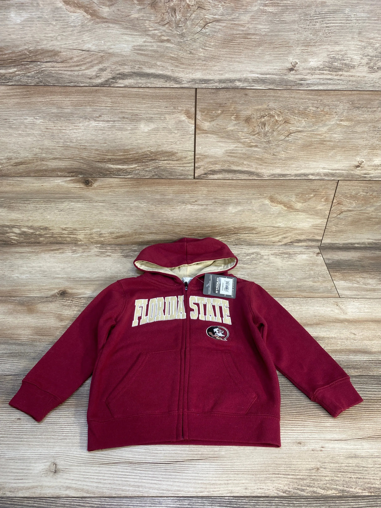 Kids maroon Florida State zip-up hoodie with logo, new with tags, on wood background