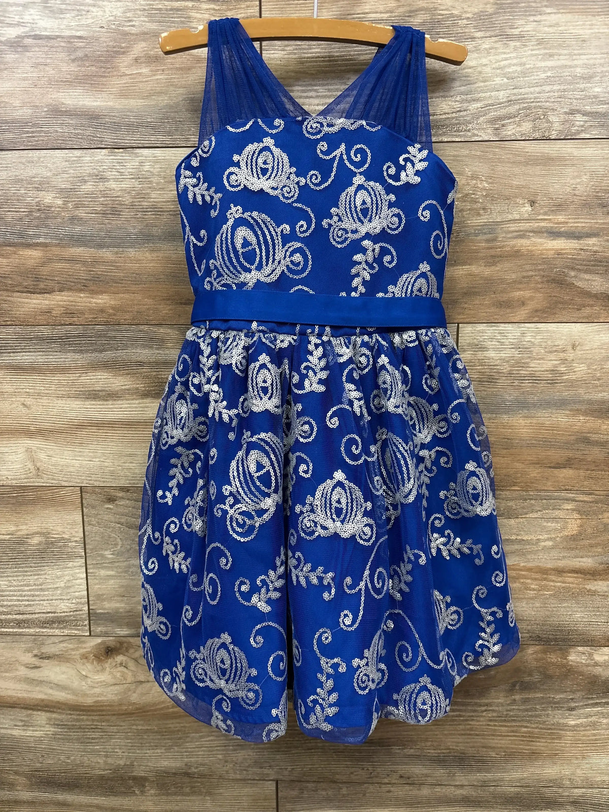Front view of Disney Cinderella sequin party dress with royal blue tulle and silver pumpkin carriage detail on wood