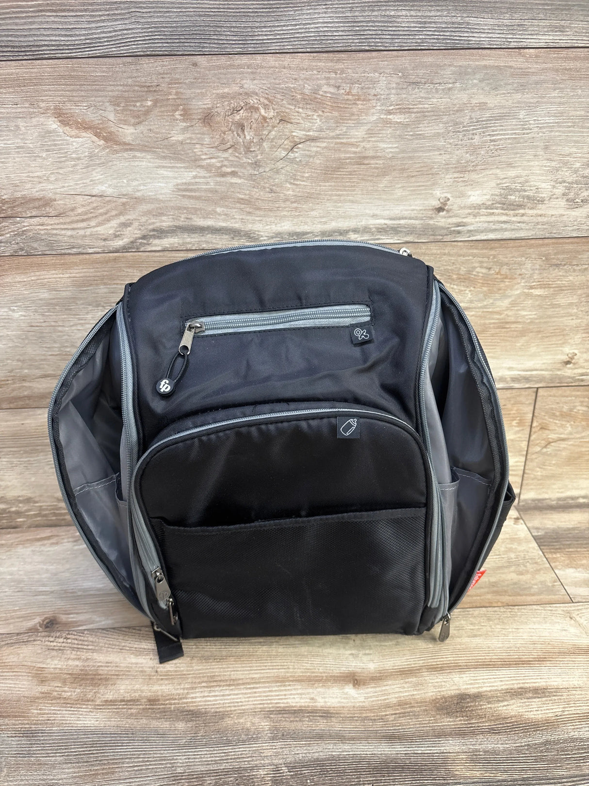 Front view of Fisher Price Kaden FastFinder diaper backpack in black with top zip, front mesh pocket, and open side pockets