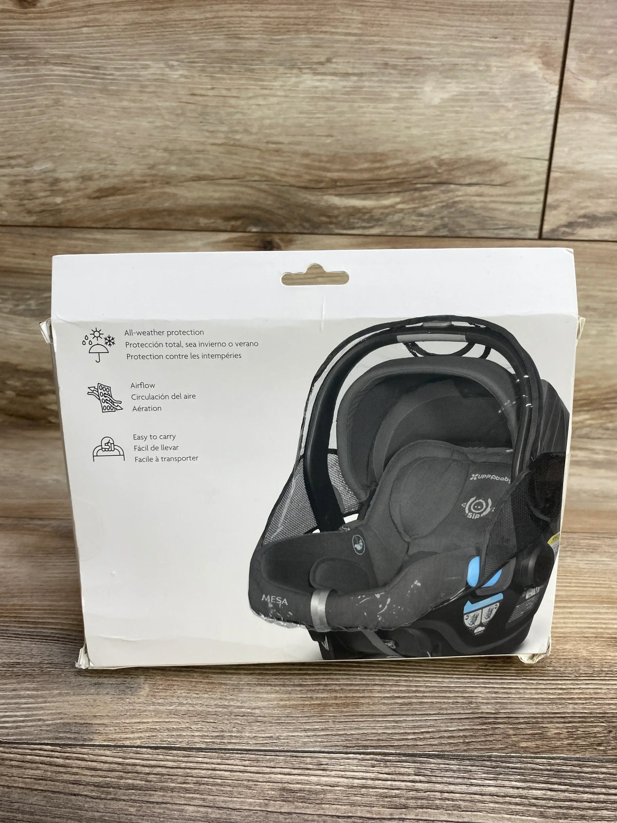 Front view of UPPAbaby Rain Shield for Mesa and Aria infant car seats showing weather protection and airflow on packaging