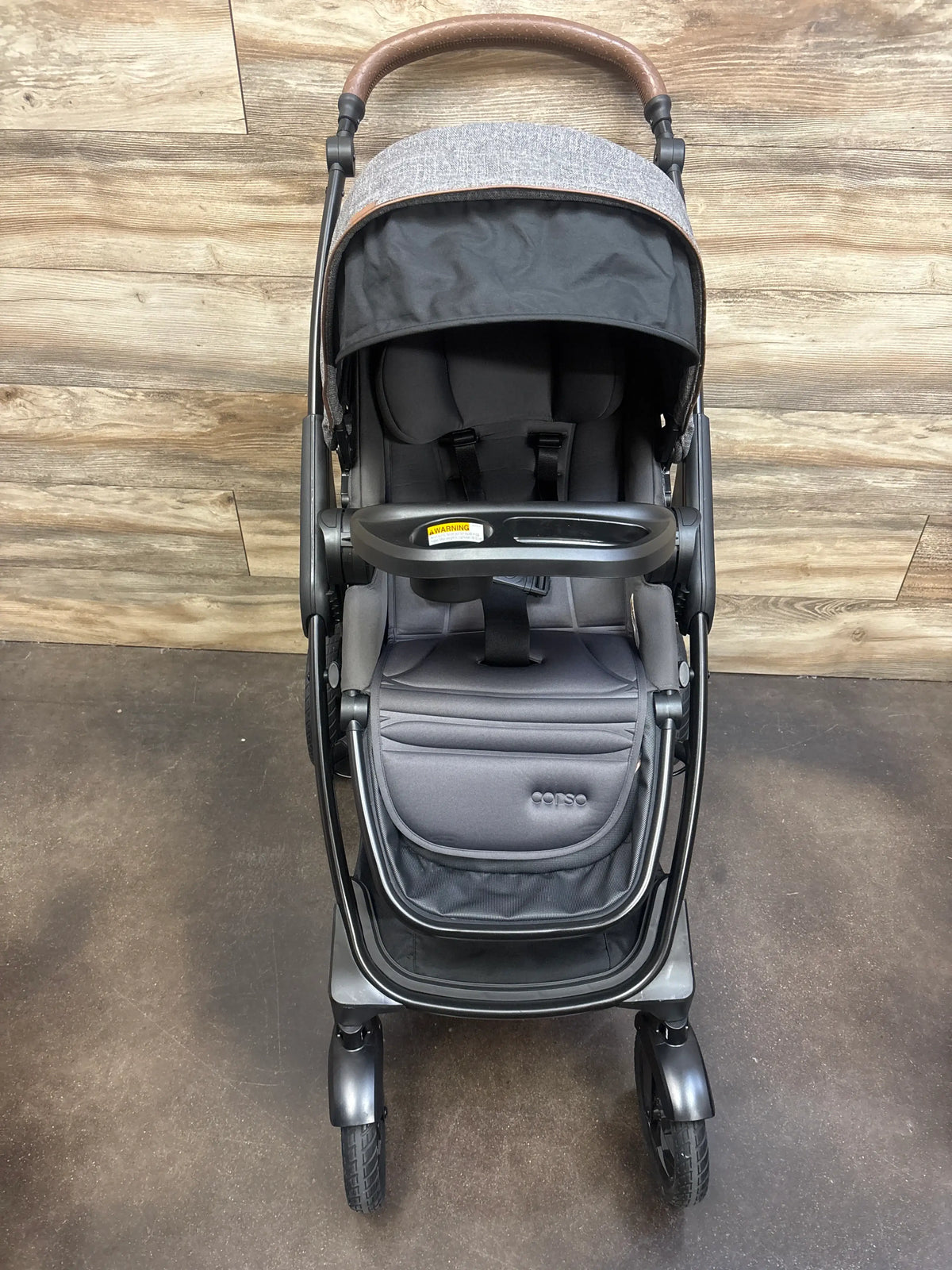 Front view of Chicco Corso Primo Stroller in Summit showcasing canopy, tray, and harness on a wood floor
