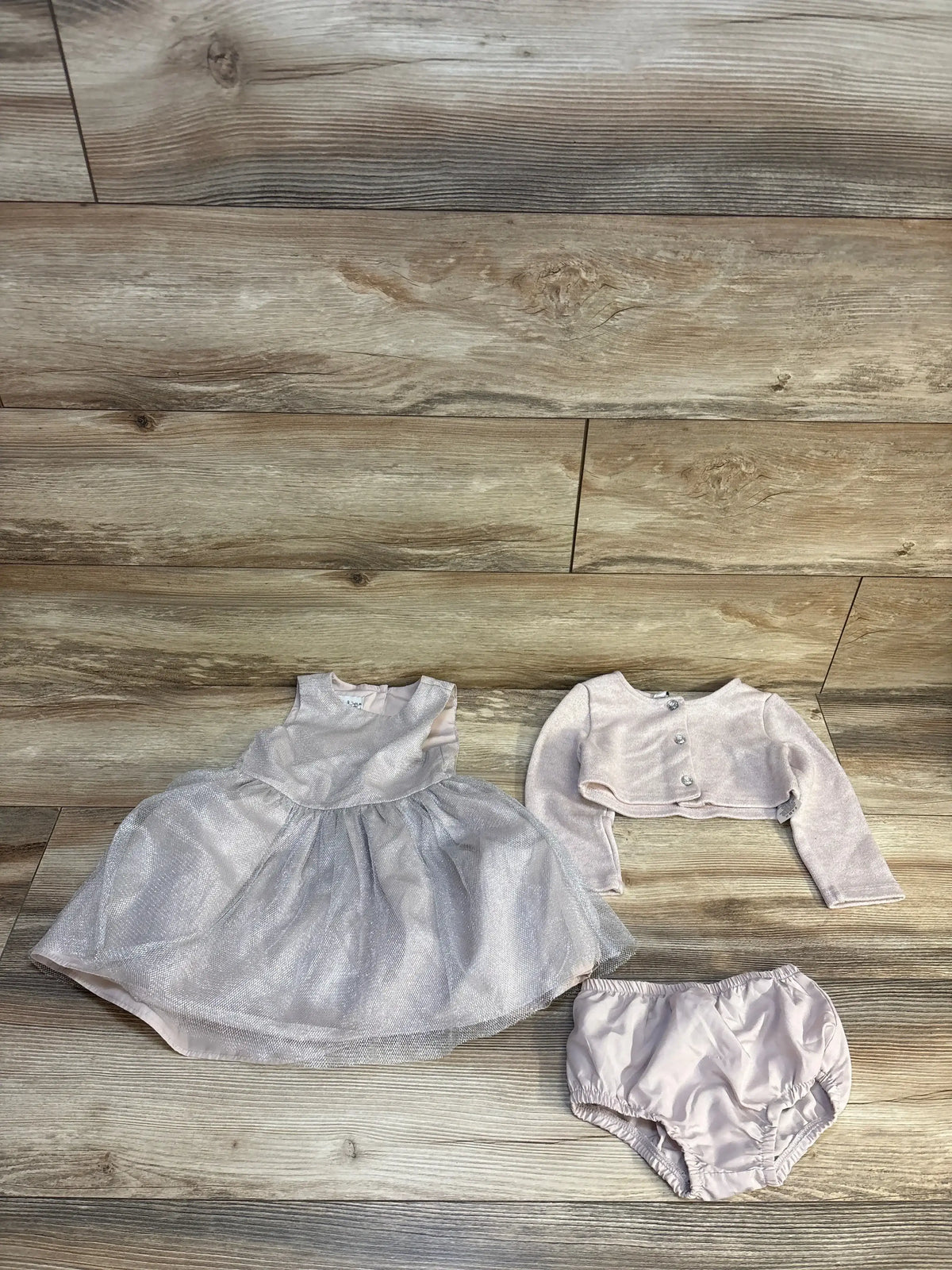 Pink baby dress set with cardigan and bloomers on wood floor, kids clothing resale