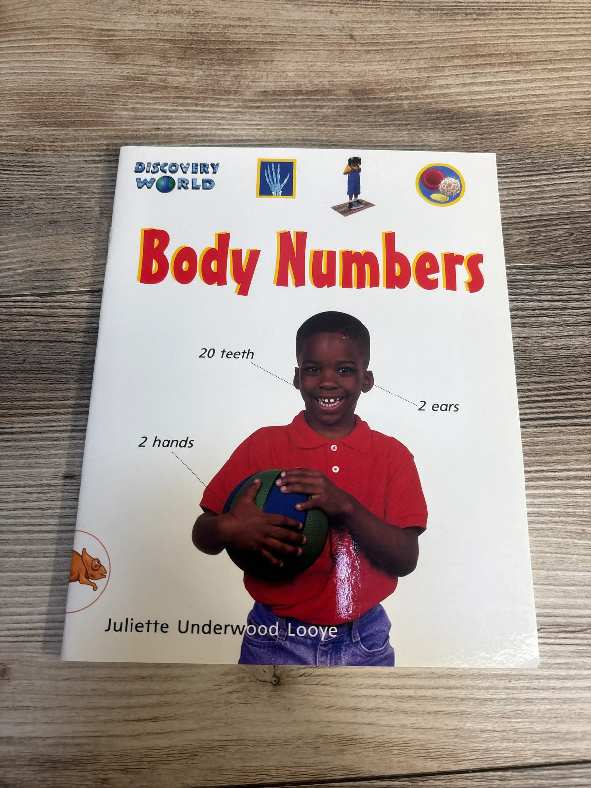 Children's educational book 'Body Numbers' featuring a smiling boy in red holding a ball