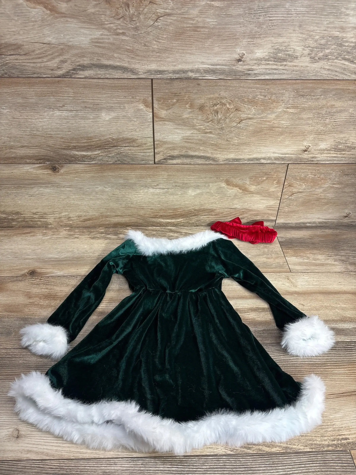 Green velvet baby Christmas dress with white fur trim and red headband, perfect for holiday photos and festive occasions.