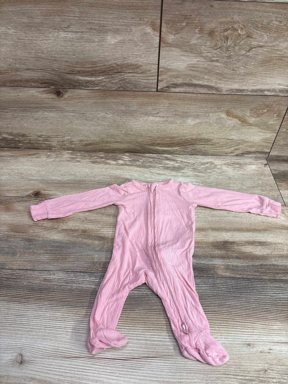 Pink Carter's PurelySoft newborn sleeper with zipper on a wooden background