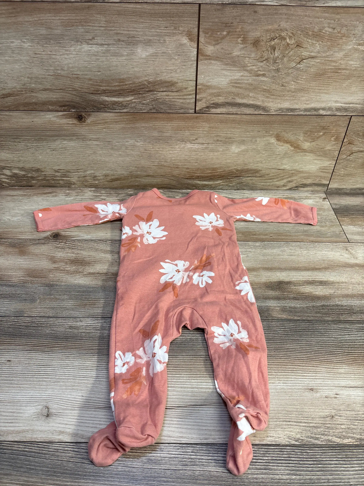 Front view of Carter’s pink kimono sleeper showcasing long sleeves, footed legs, and white floral print on a wood-look floor