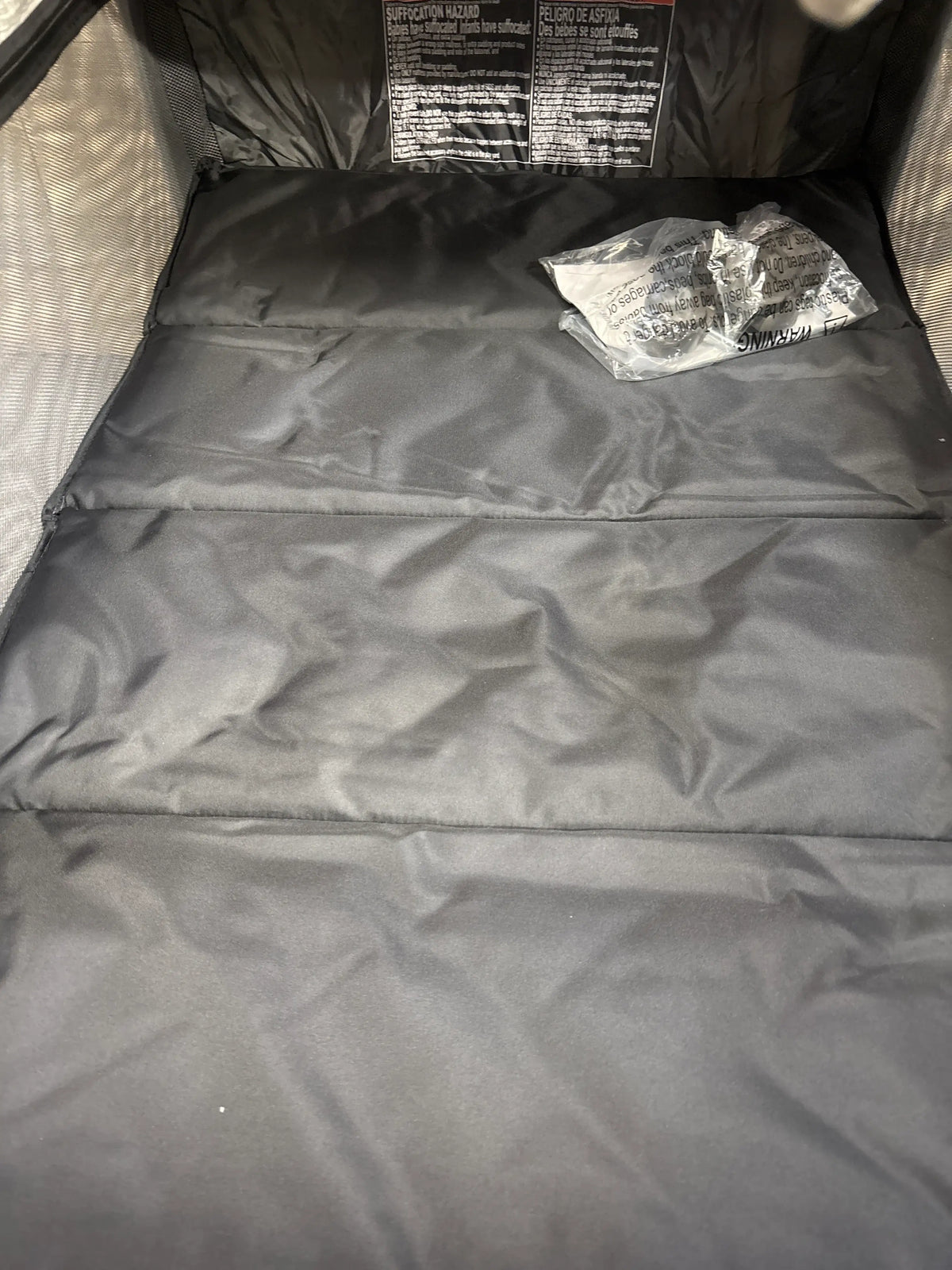 Interior view of Pamo Babe Just Right playard with bassinet and changer in grey showing padded base and mesh sides