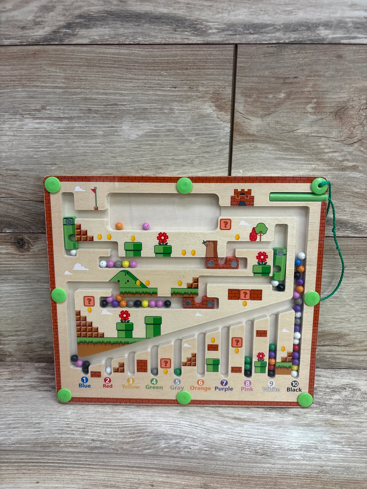 Front view of ToyerZ Magnetic Color and Number Maze showcasing numbered color-coded ball paths with a wood-grain background