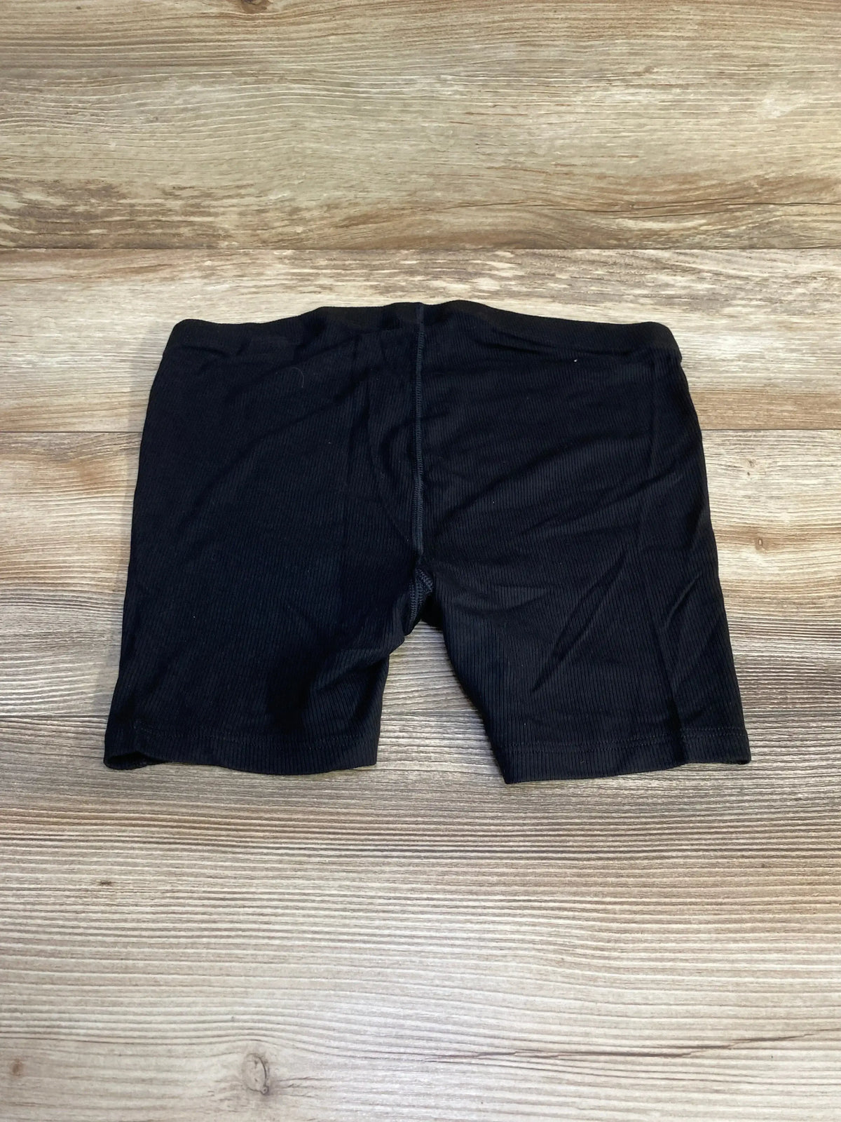 Flat lay of black Gap maternity ribbed PJ shorts size XS showing elastic waistband and ribbed fabric on wood background
