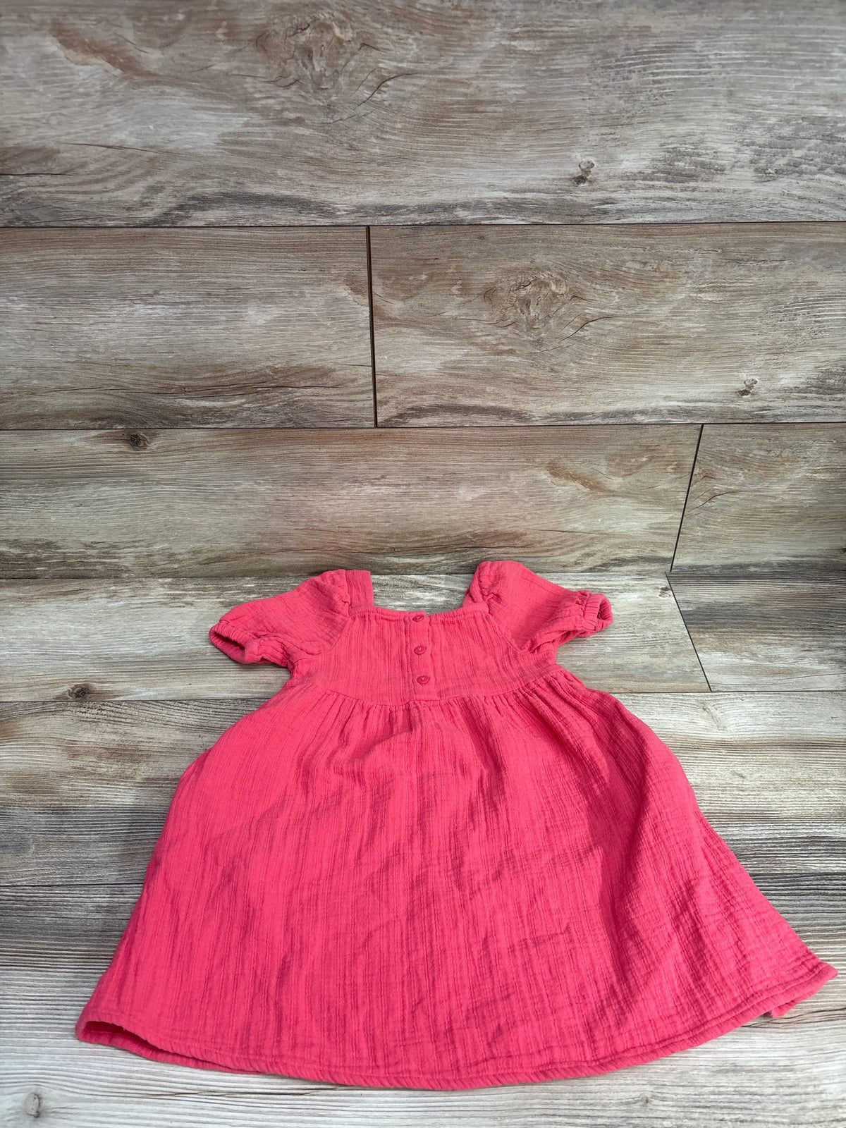 Hot pink Cat & Jack Henley puff sleeve dress for toddlers on a wooden background