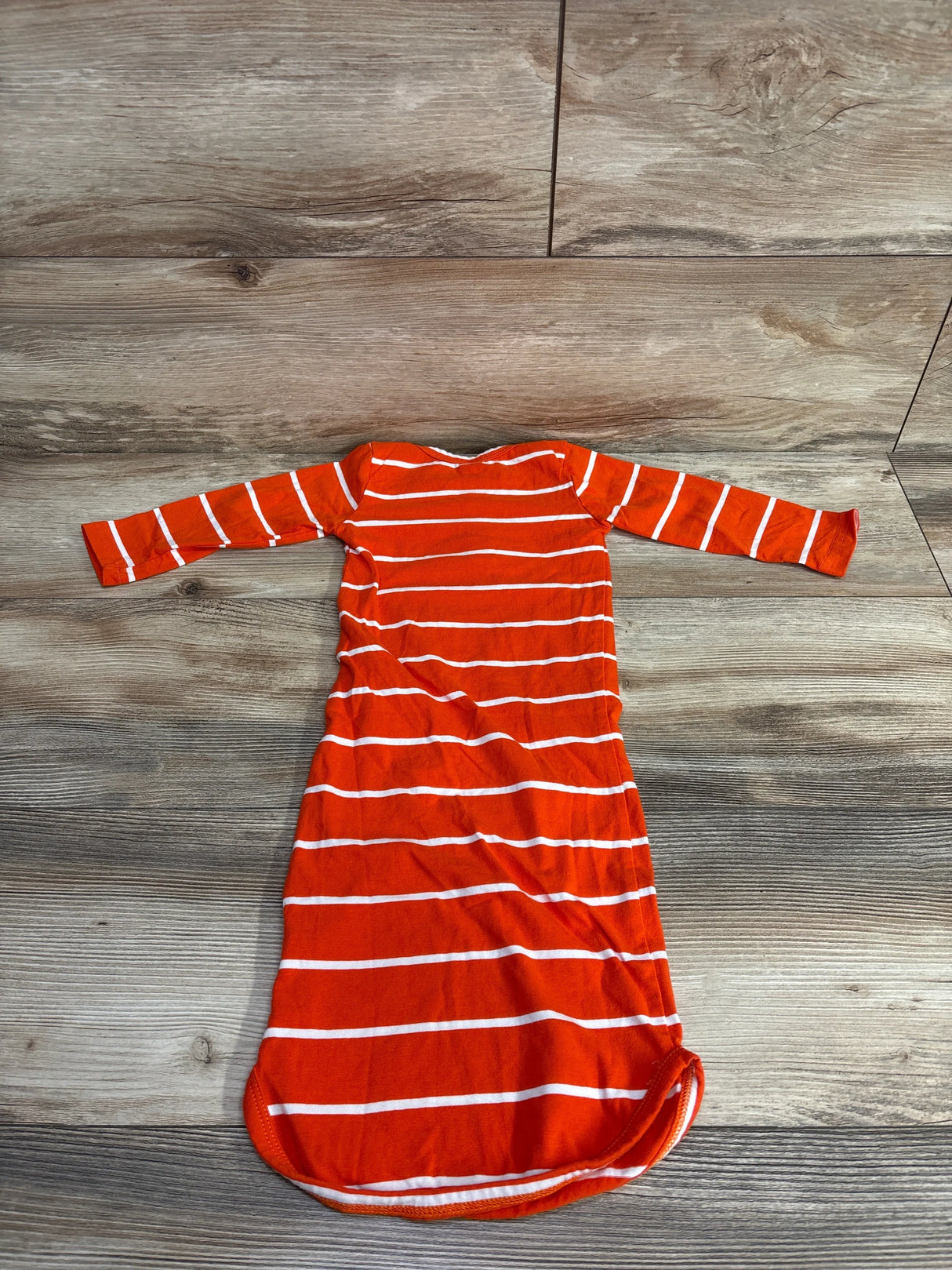 Red and white striped baby sleep gown with long sleeves on wood floor
