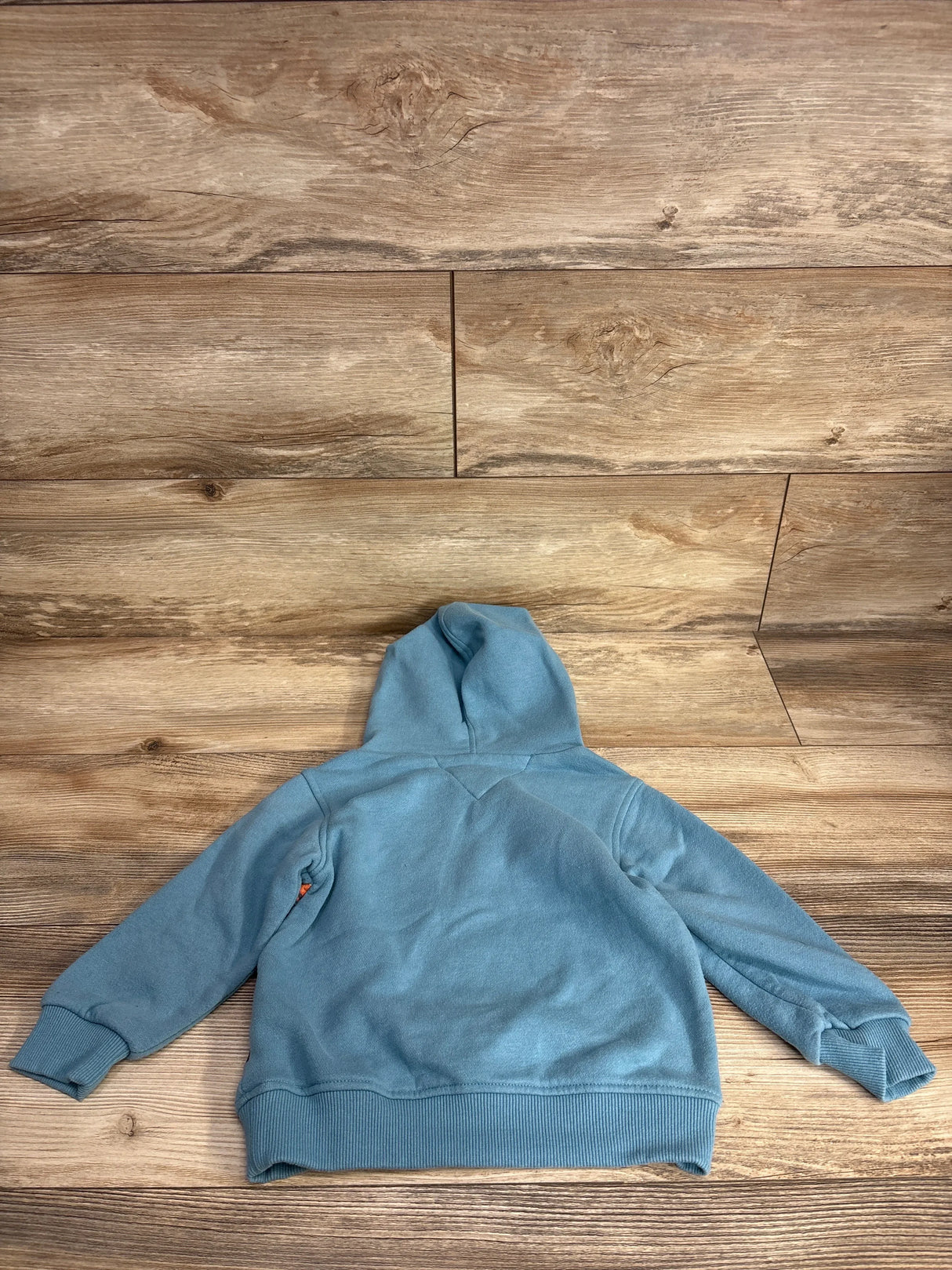 Blue kids hoodie laid flat on wooden background, long sleeves, cozy children's clothing