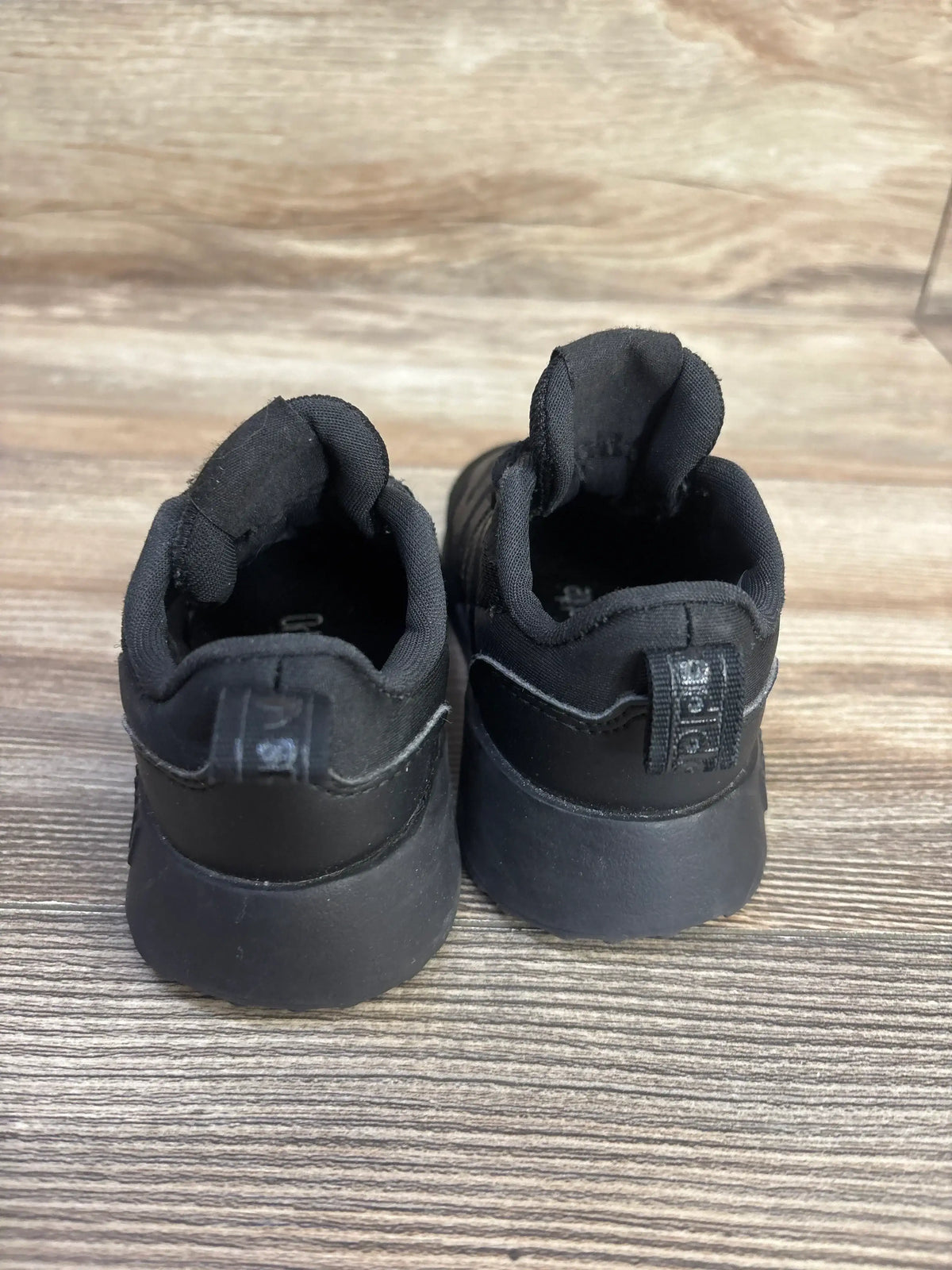 Rear view of Adidas Multix I toddler shoes (size 6C) showing padded heel, pull tabs, and thick black sole on wood floor
