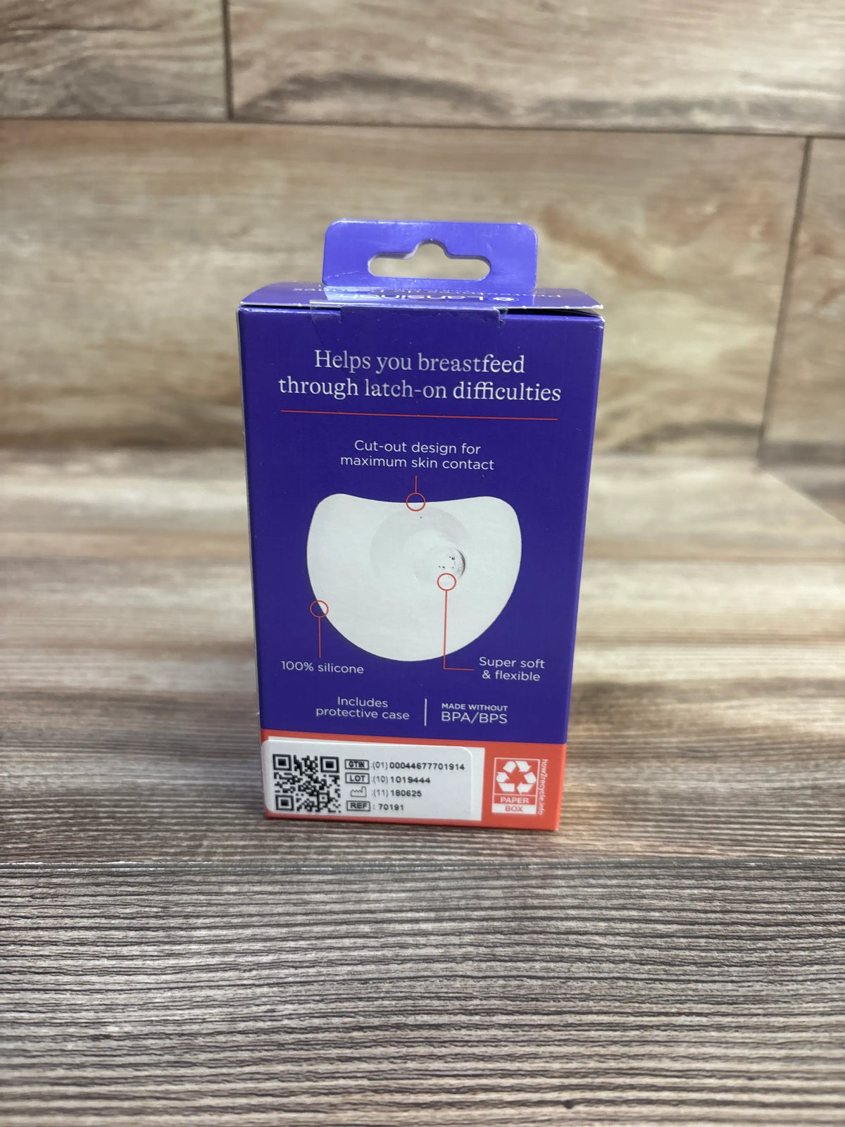 Front view of Lansinoh Contact Nipple Shields, 2-pack, 20 mm, in purple packaging on a wood-patterned surface