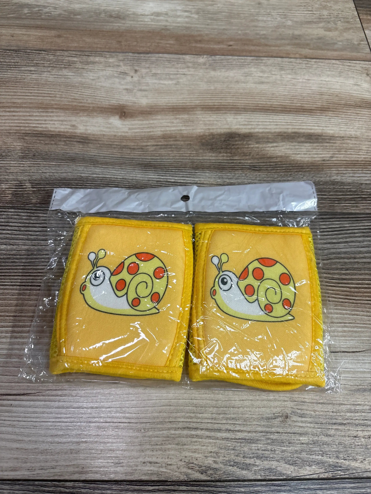 New Lipfer baby crawling knee pads in yellow with snail design, packaged in clear plastic.