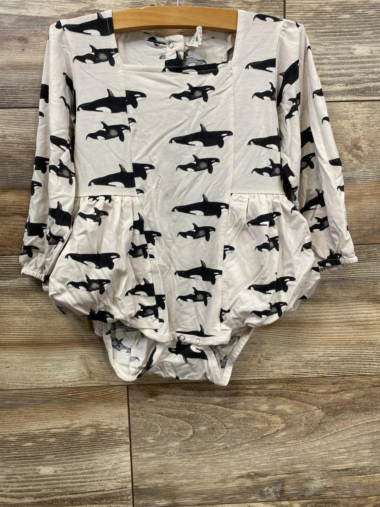 Front view of Kate Quinn Orca Whale skirted bodysuit in white with black orca print and gathered skirt overlay