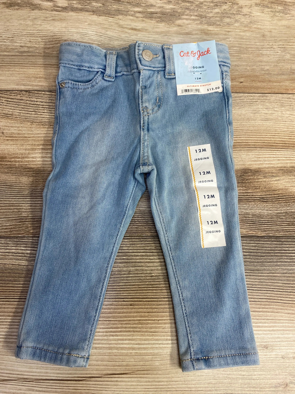 Light blue baby jeggings size 12 months with adjustable waist by Cat & Jack on wooden surface