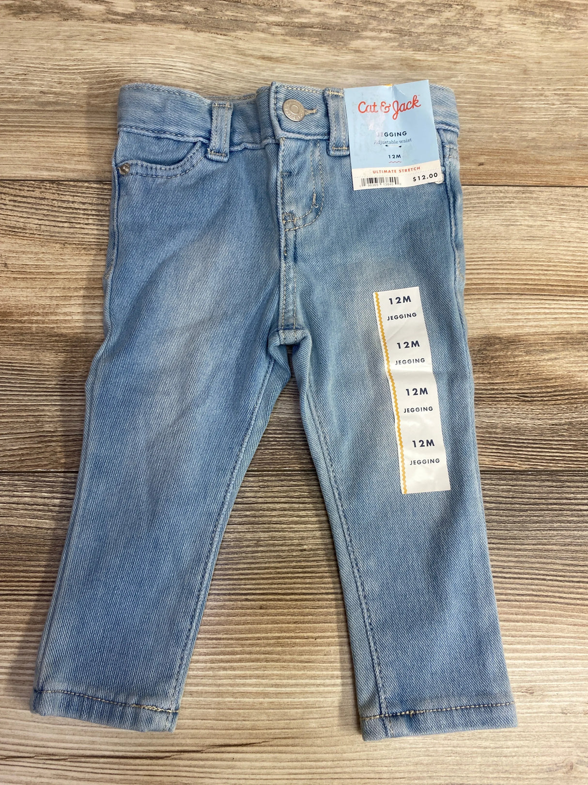 Light blue baby jeggings size 12 months with adjustable waist by Cat & Jack on wooden surface