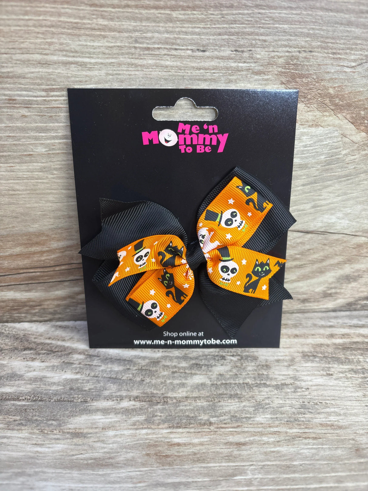 Halloween-themed hair bows with skulls and cats on orange ribbon, perfect for kids' festive outfits.