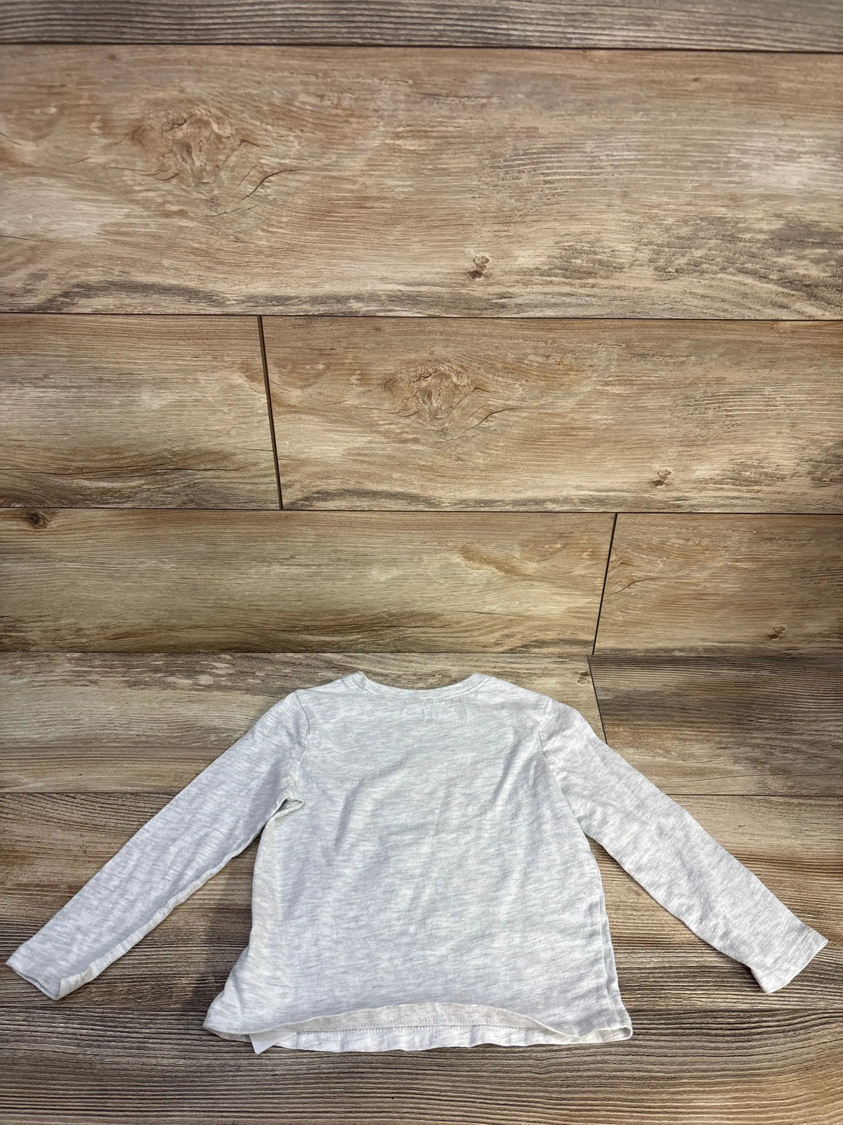 Front view of Old Navy Nothing But Net shirt, gray, size 3T, showcasing long sleeves and a crew neck on a wood background