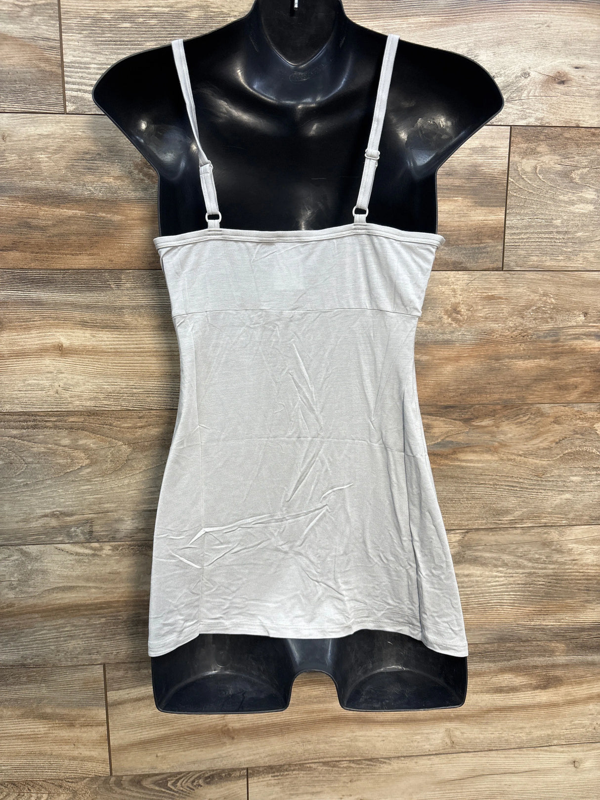 Light gray camisole tank top with adjustable straps on a black mannequin, wood background