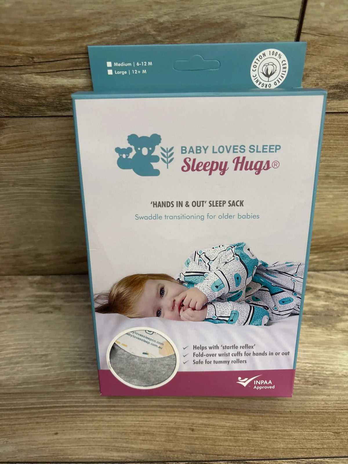 Baby Loves Sleep Sleepy Hugs swaddle sack packaging for older babies, on wood background