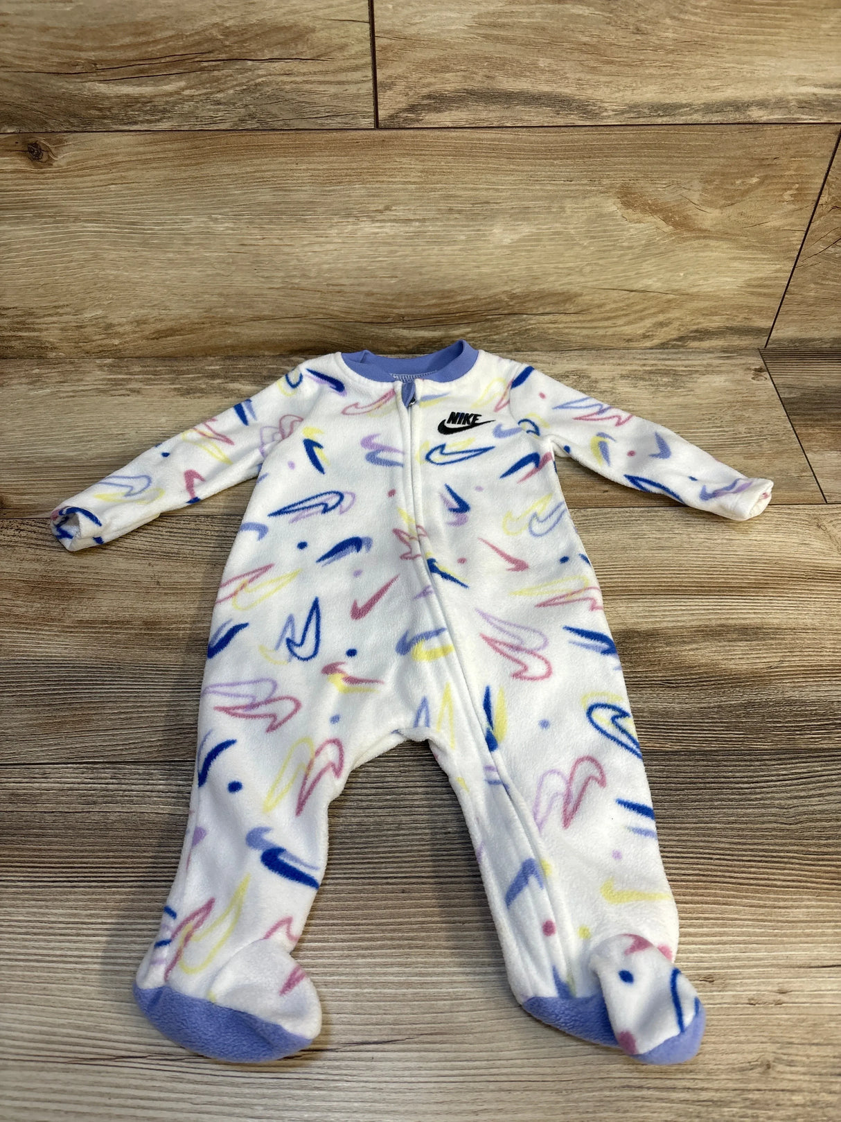 White baby sleeper with colorful squiggle print and zipper, Nike logo on chest, footed design