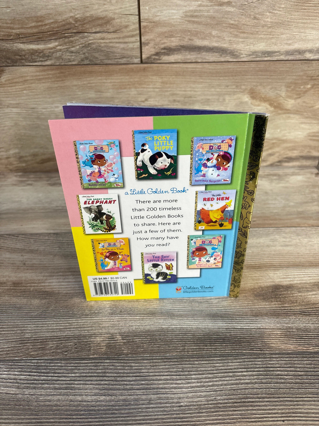 Back cover of a Little Golden Book featuring classic children's book covers on a wooden surface.