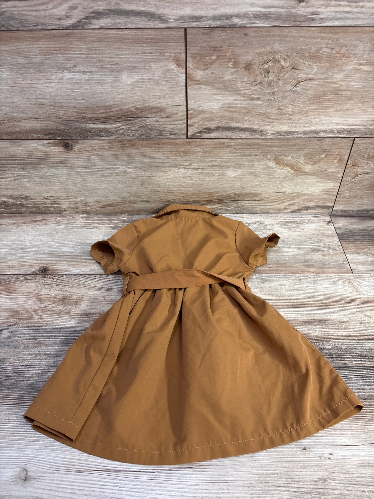 Back view of Shein belted polo dress in brown showcasing short sleeves, waist belt and flared skirt on wood plank background