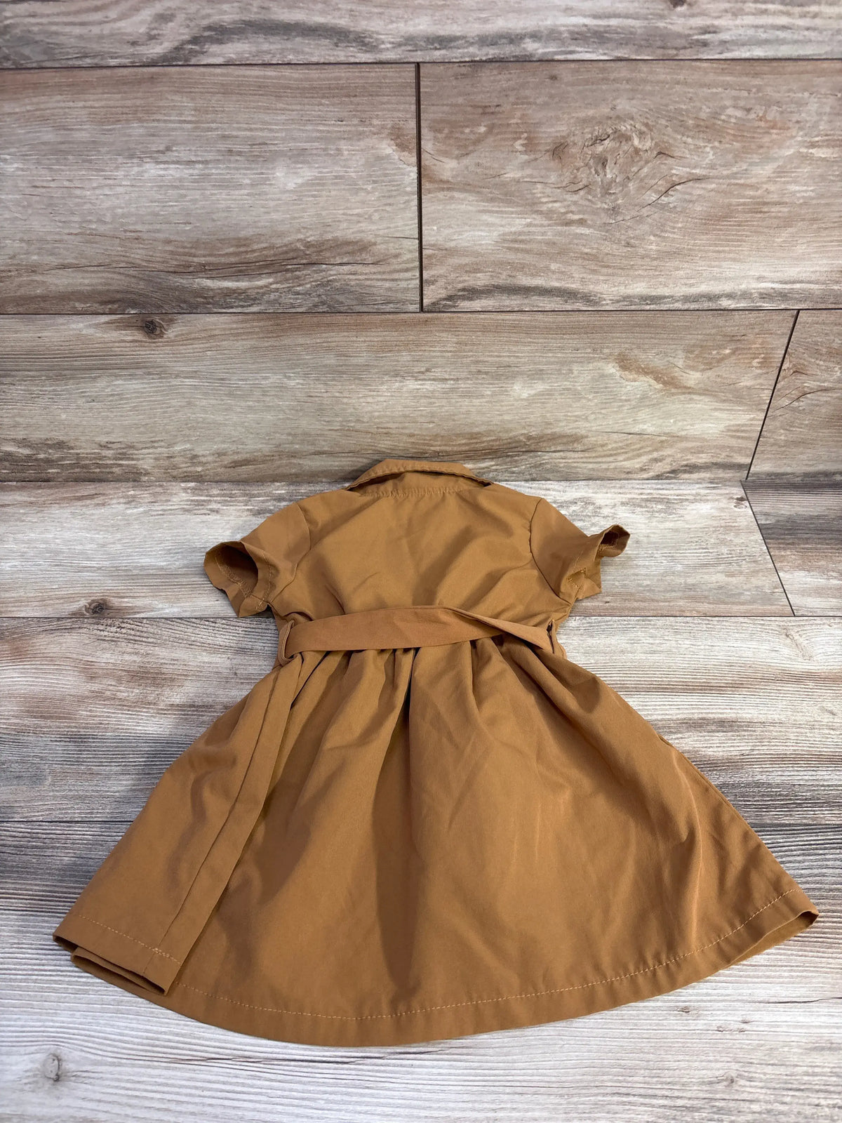 Back view of Shein belted polo dress in brown showcasing short sleeves, waist belt and flared skirt on wood plank background