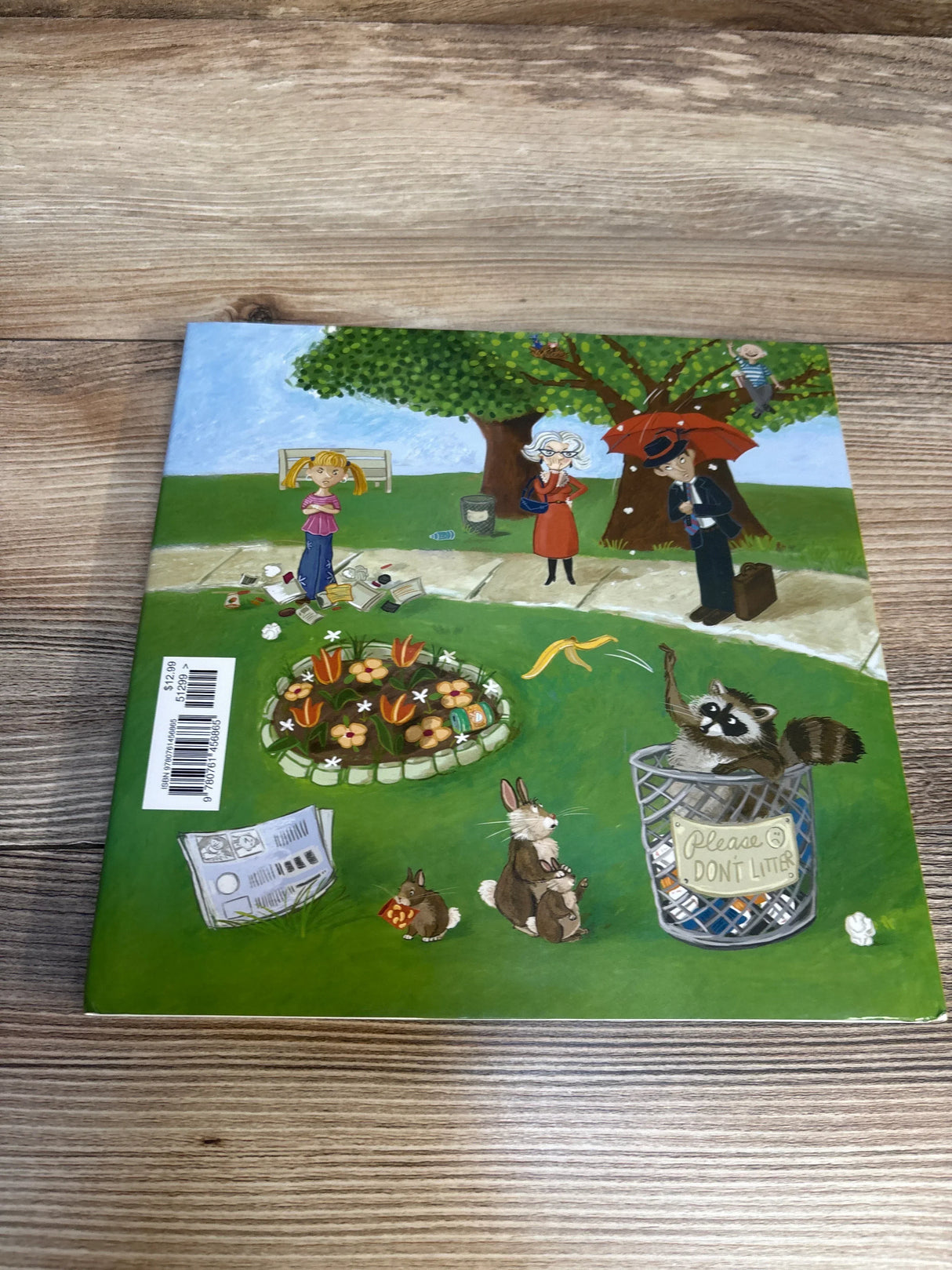 Back cover of What If Everybody Did That? hardcover book showcasing illustrated park scene with girl, raccoon in a trash can labeled Please don't litter, flowers on a wood table