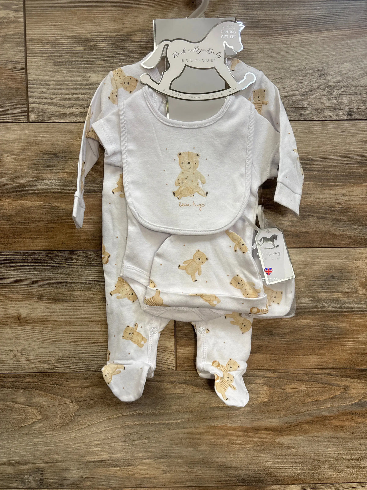 Flat lay of Rock a Bye Baby Boutique 5-piece gift set with teddy bear print on a wooden background