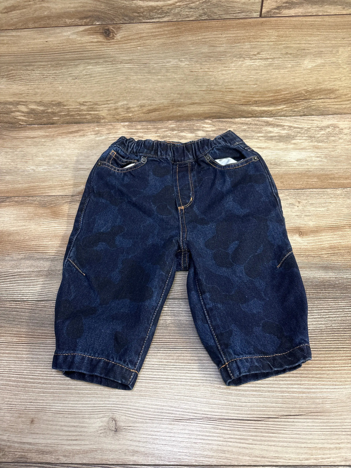 Baby Gap blue camouflage print barrel jeans for infants size 12-18m on a wood background
