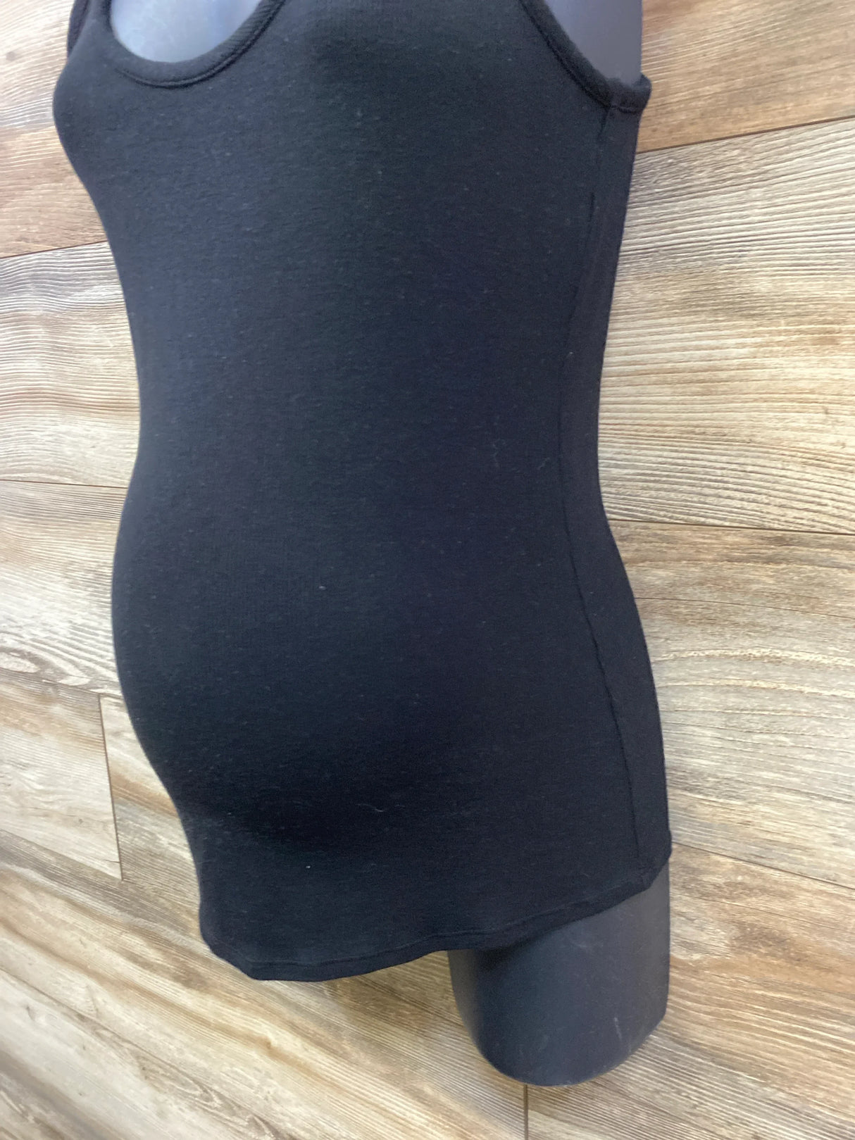 Black maternity tank top on mannequin with wood background