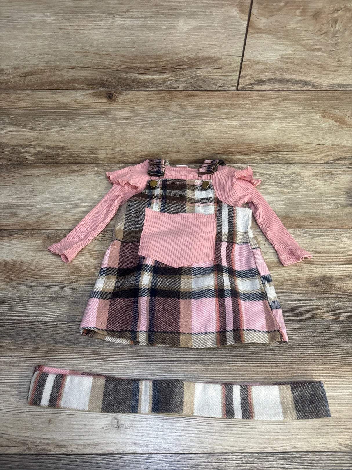 Girls plaid jumper dress with pink long sleeve shirt and matching headband on wood floor