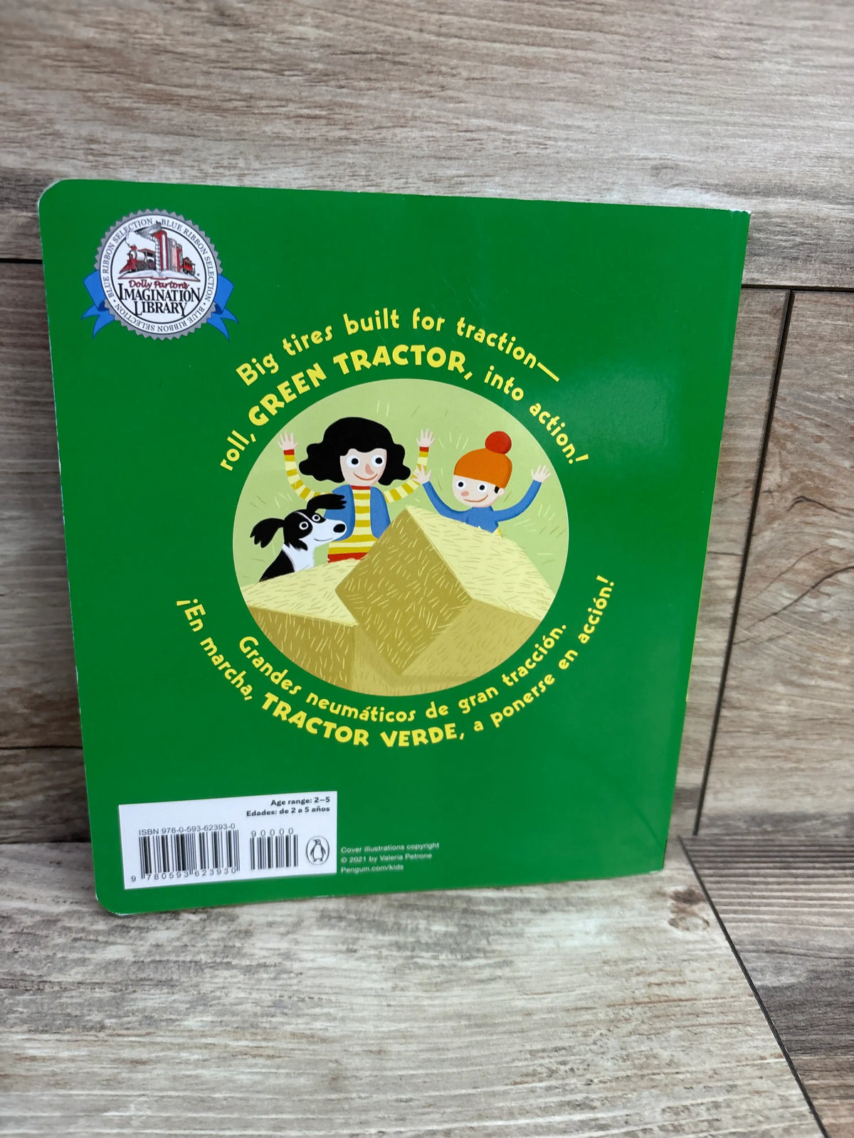 Back cover of Green Tractor Tractor Verde paperback book showing children and a dog on hay bales with traction text