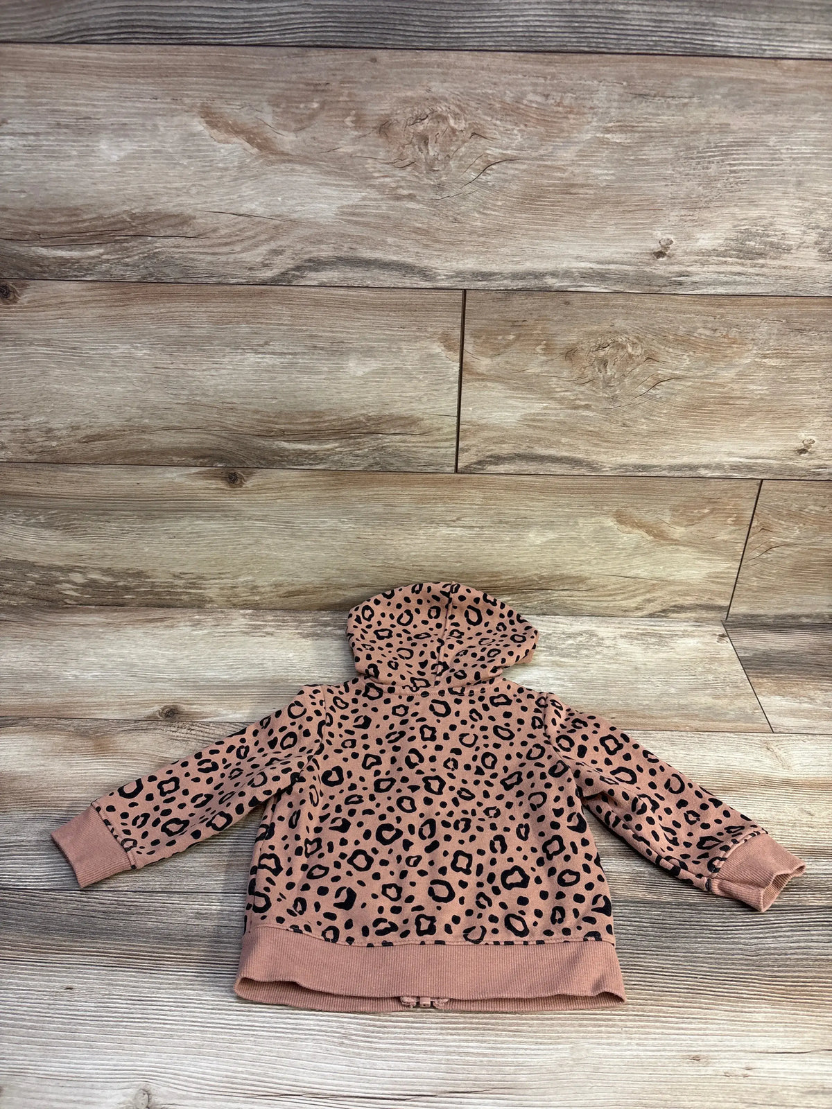 Back view of Cat & Jack toddler hooded jacket showcasing brown leopard print pattern laid flat on wooden background