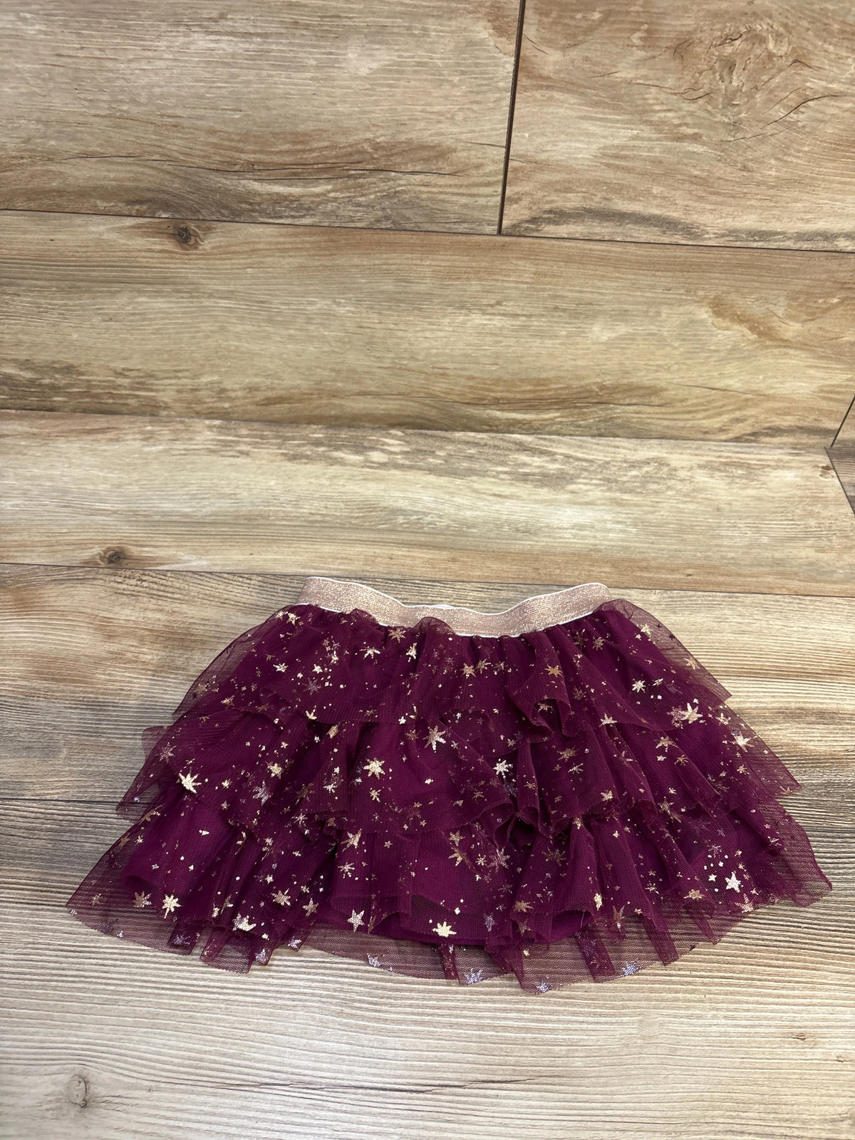 Jumping Beans layered purple tulle skirt with gold star glitter accents on a wood background