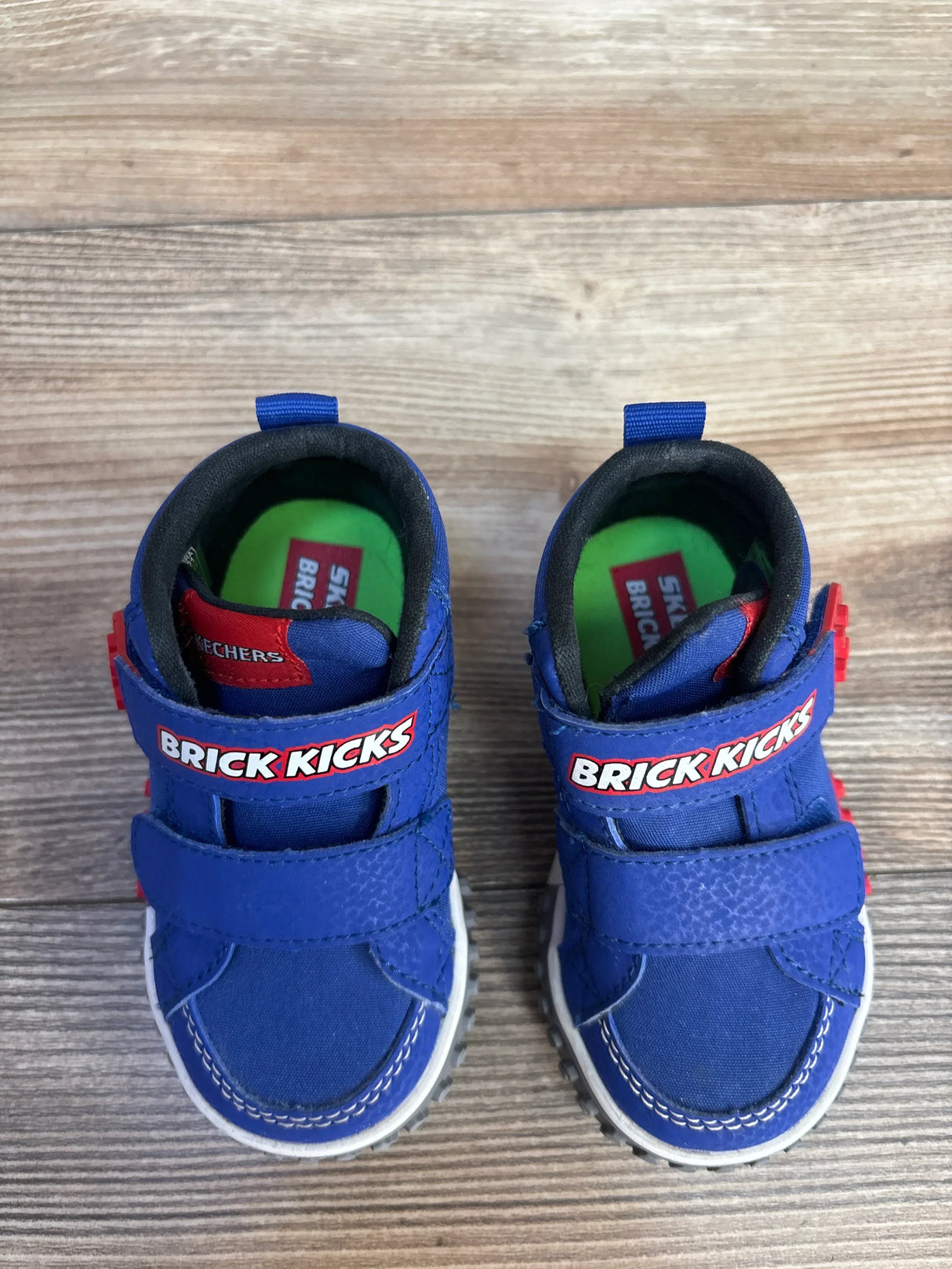 Blue Skechers Brick Kicks toddler shoes on wood floor, Velcro straps, green insoles