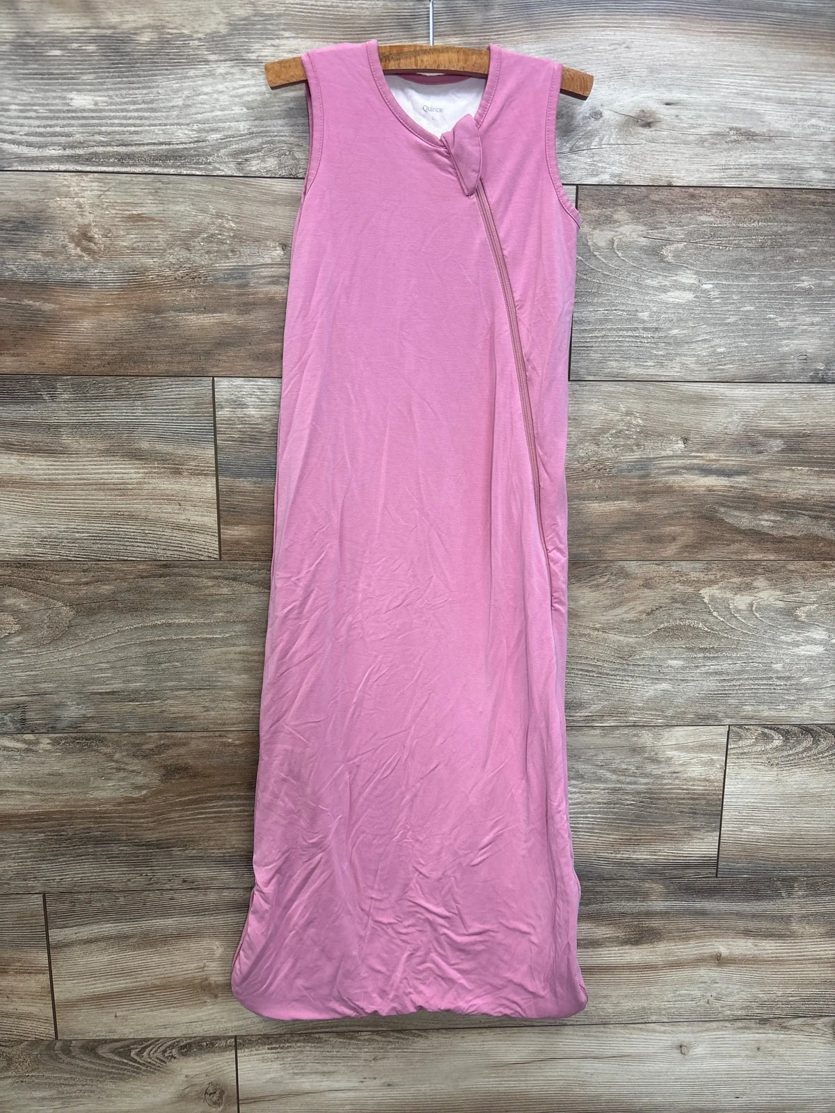 Pink sleeveless baby sleep sack with front zipper on wooden background