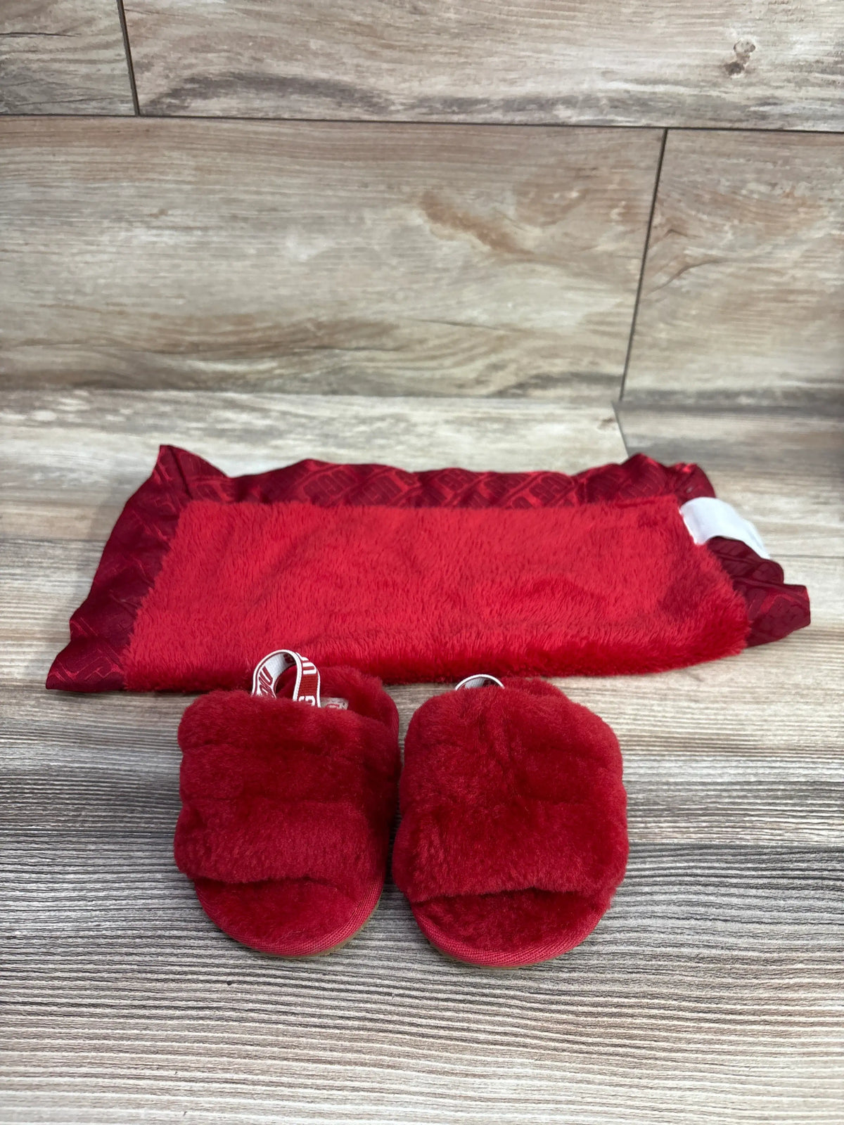 Red Me n Mommy To Be baby blanket and matching fluffy slides on a wood surface