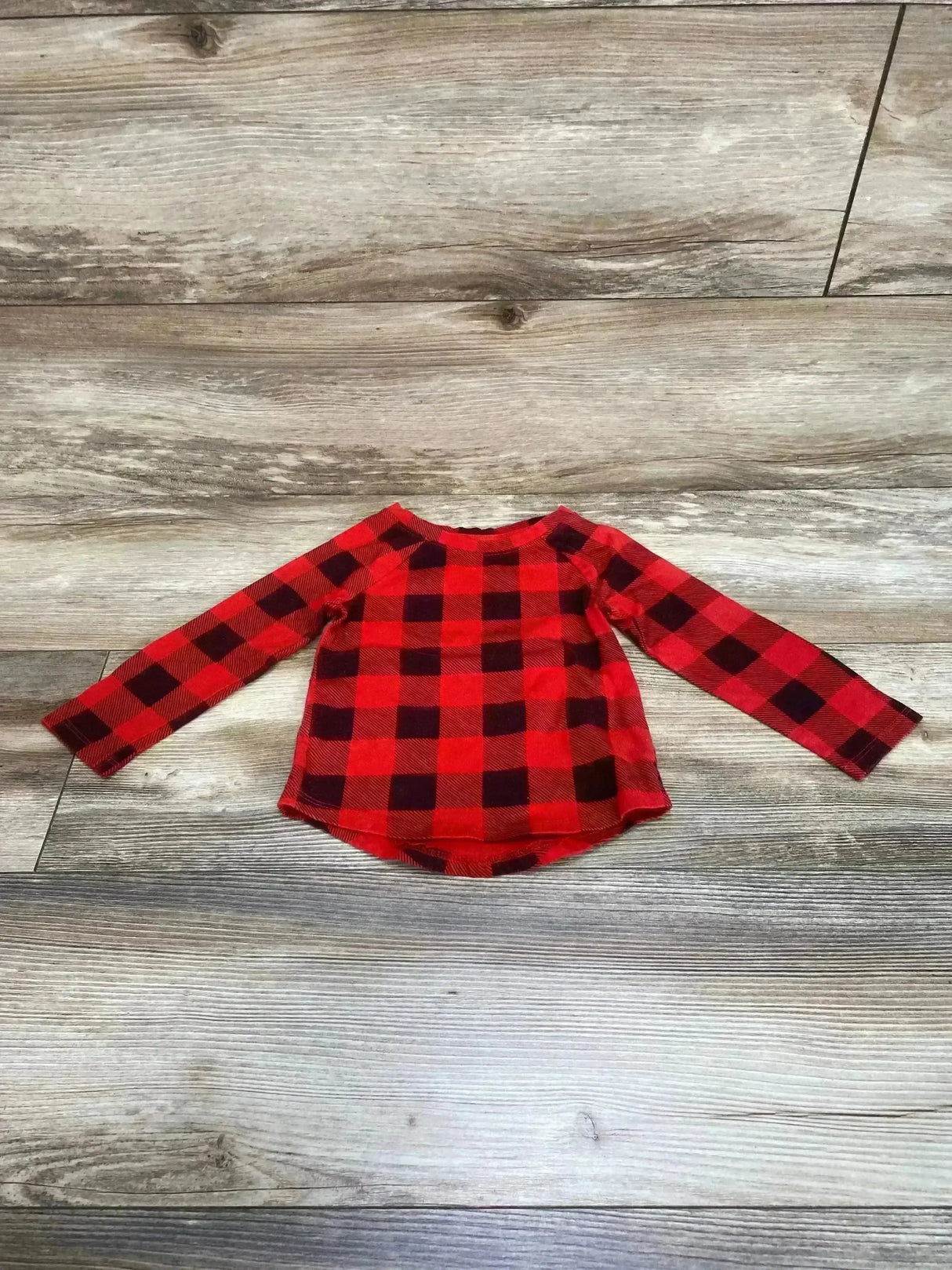 Back view of Cat and Jack shirt in red buffalo check showcasing long sleeves and curved hem on wood plank floor