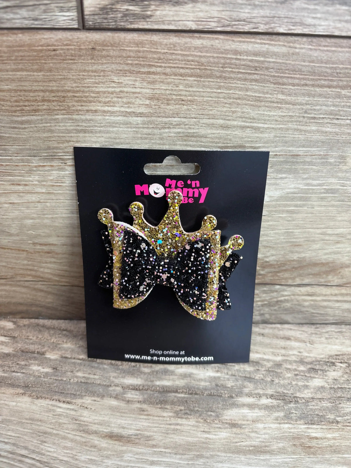 Front view of layered crown glitter hair bow in black and gold showcasing glitter finish and layered crown shape on a black branded display card