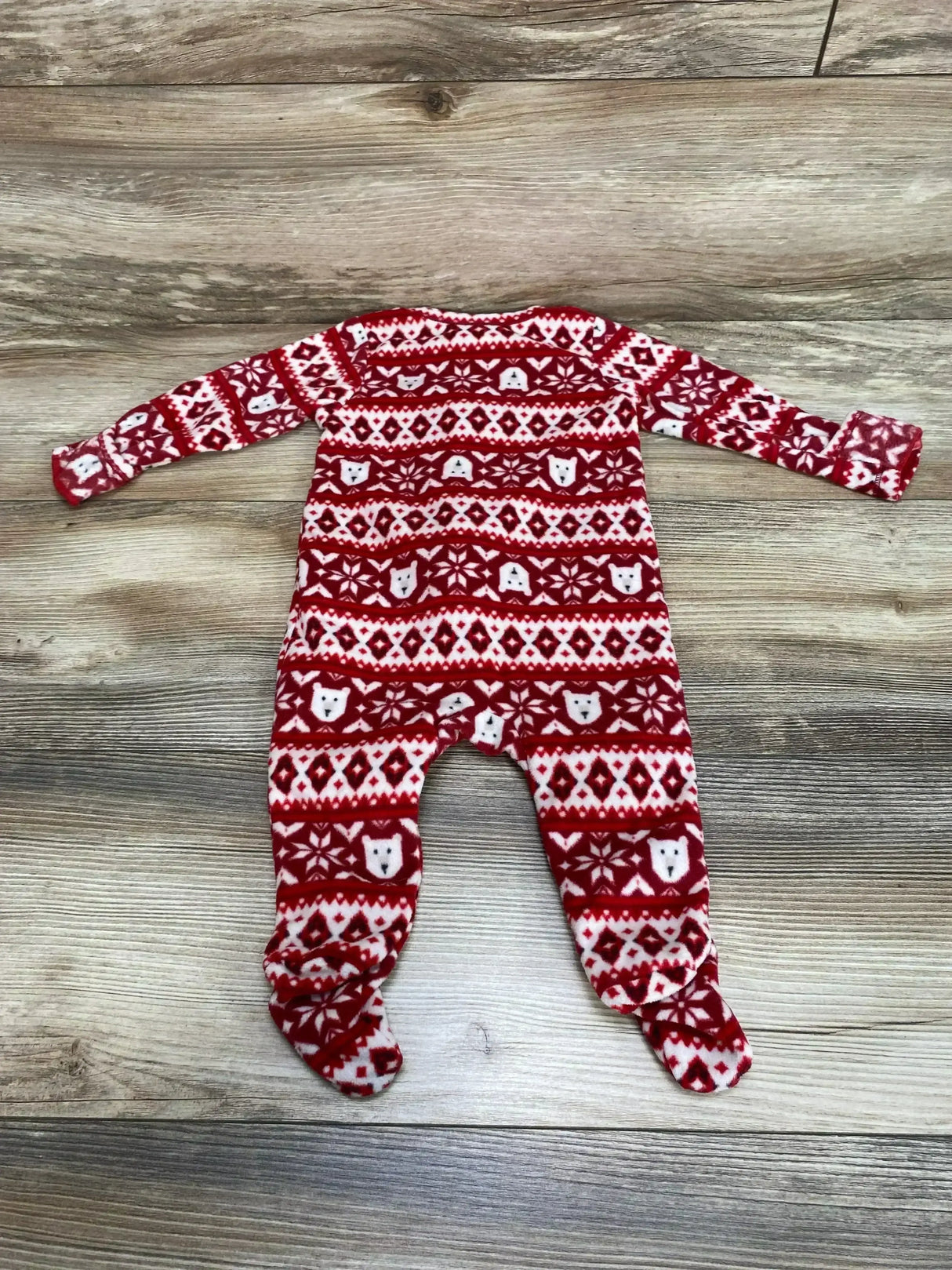 Flat lay of Old Navy red Fair Isle footed blanket sleeper (3-6 months) showing polar bear and snowflake pattern on wood floor
