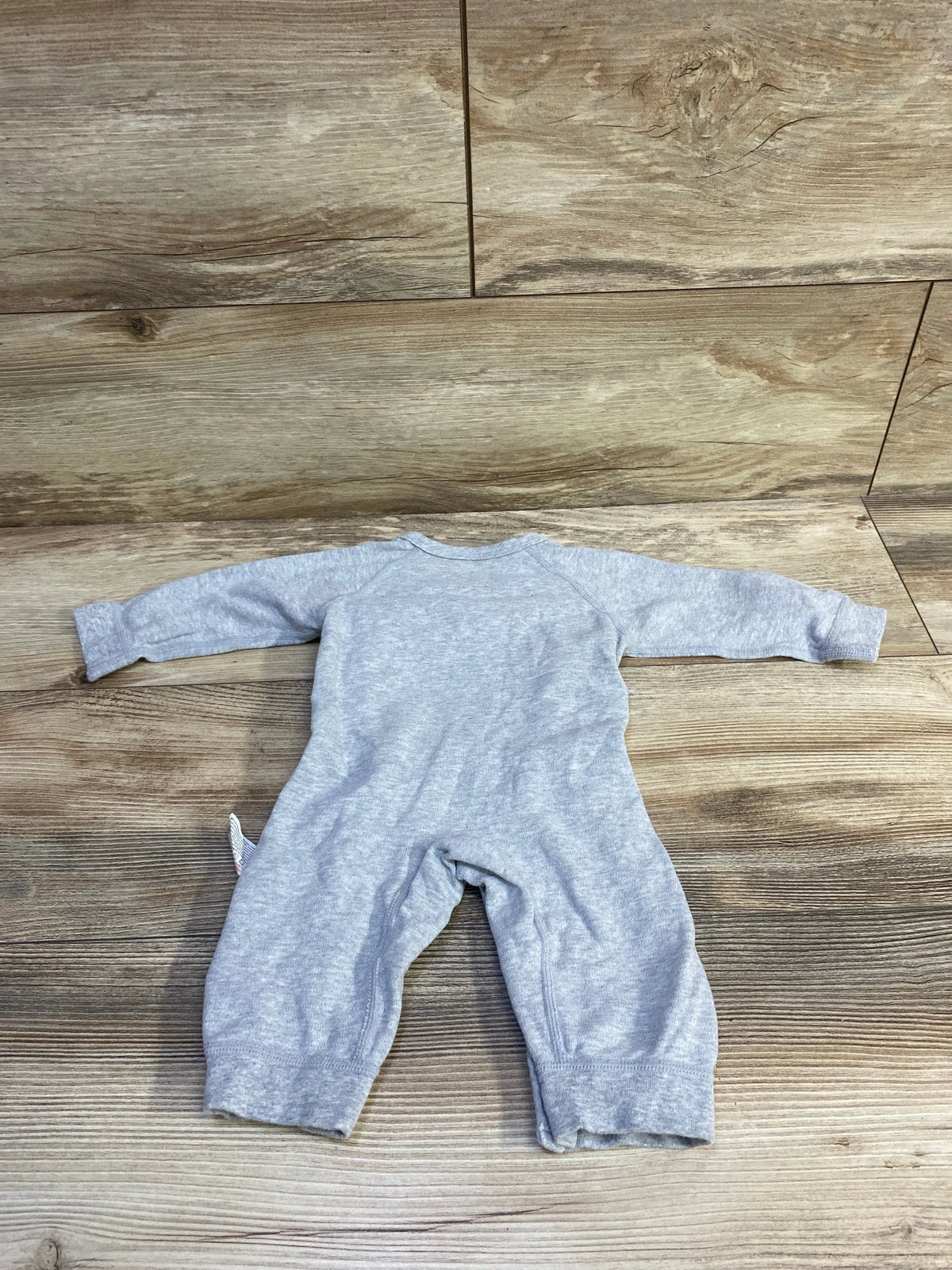 Back view of a grey Cherie Kids footless kimono sleeper for babies, laid on a wood floor.
