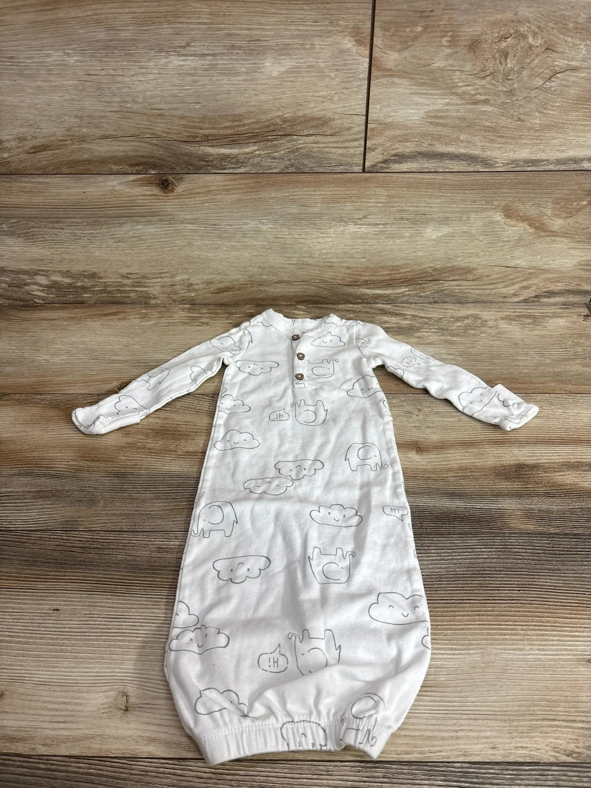 Top-down view of white Carter’s Cloud Henley sleeper gown with long sleeves, three-button front, and cloud-elephant print
