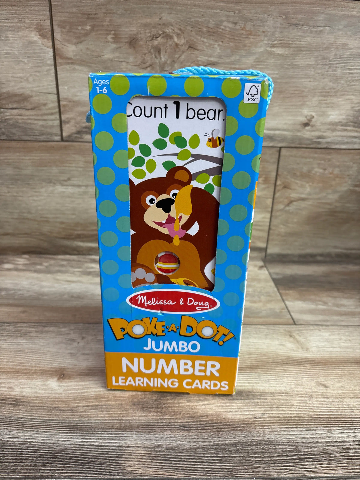 Front of Melissa and Doug Poke a Dot Jumbo Number Learning Cards box with bear artwork and Count 1 bear text on wood