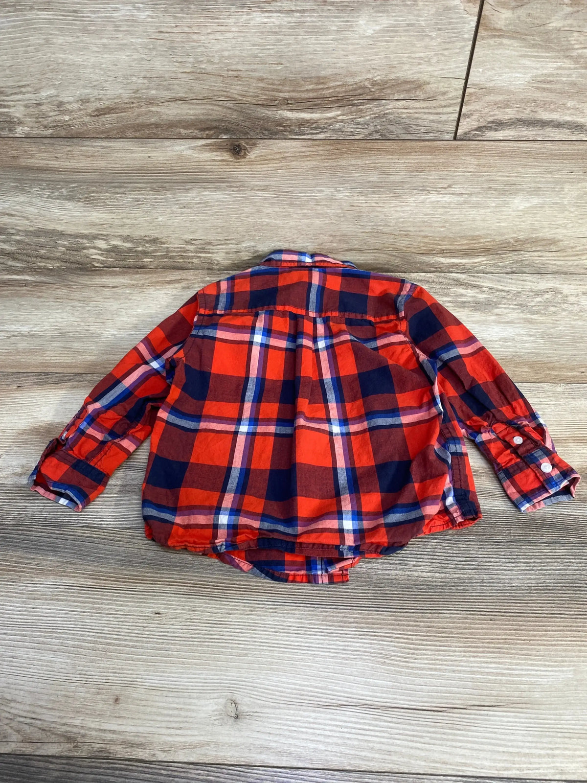 Back view of Gymboree toddler plaid button-up shirt size 2T showing long sleeves, curved hem, and red and navy check on wood background