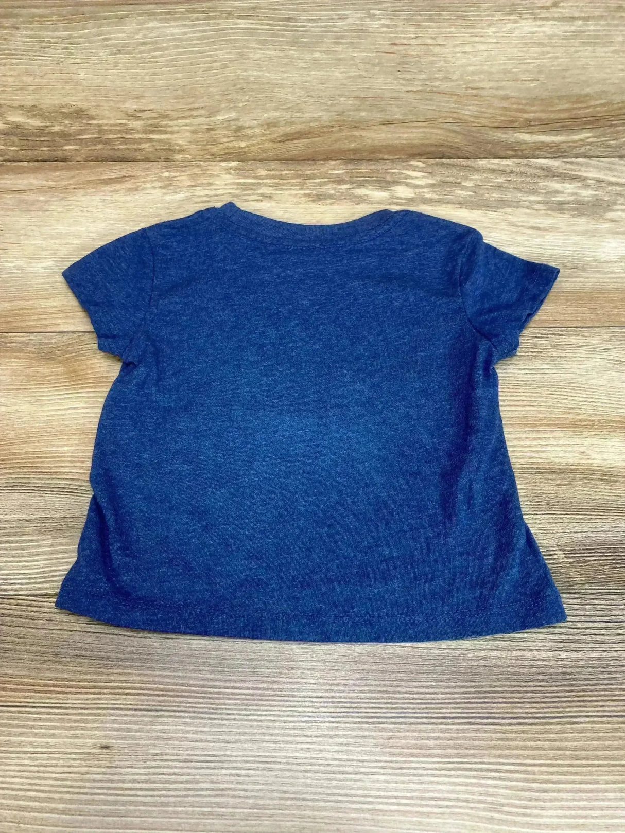 Flat lay back view of Diana Ross toddler blue t-shirt, size 12 months, short sleeves on wood background