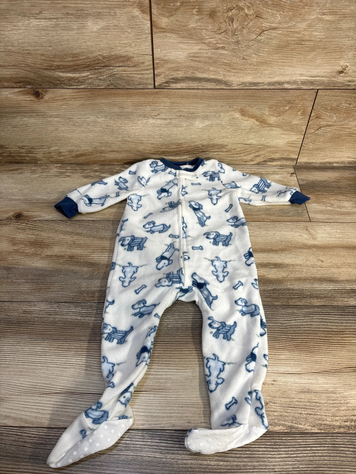 Front view of Chick Pea white blanket sleeper showcasing blue animal print, zipper front, and footed design on a wood floor